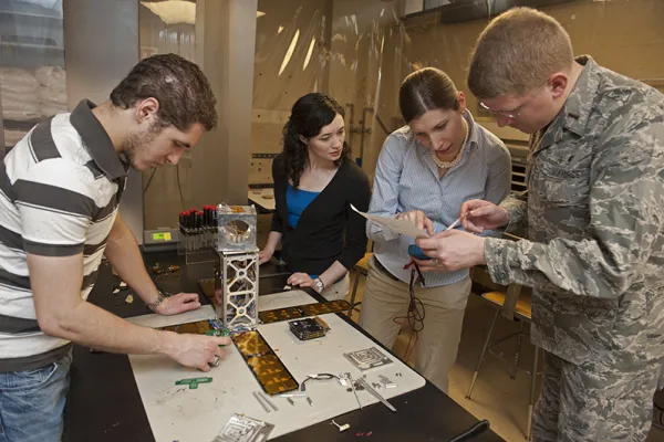 Summer research interns help to build the MicroMAS CubeSat to demonstrate microwave sounding of the atmosphere from a miniature satellite about the size of a loaf of bread.