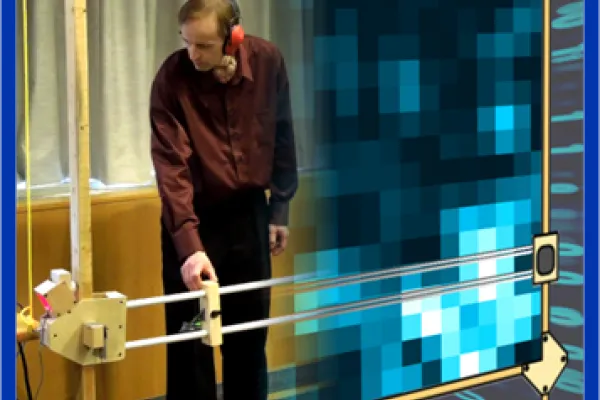 An instructor stands at a large square grid, demonstrating how to adjust the X and Y axis to draw out holograms in real time.