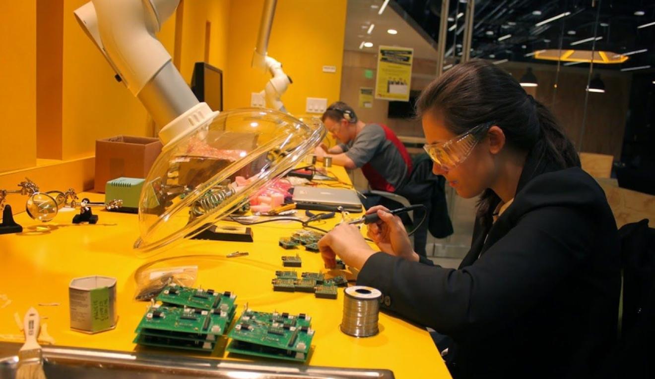 A young woman works on the internal wiring on a CLAIRITY node. 